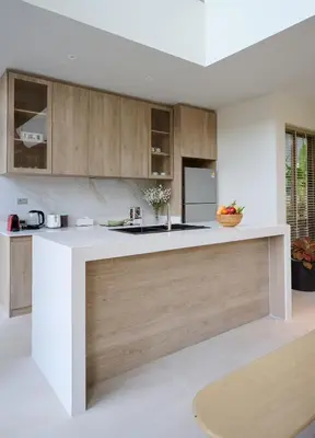 a kitchen with a white counter and wooden cabinets at New Cozy 3BR Pool Villa Best Location- Boat Avenue in Ban Thalat Choeng Thale