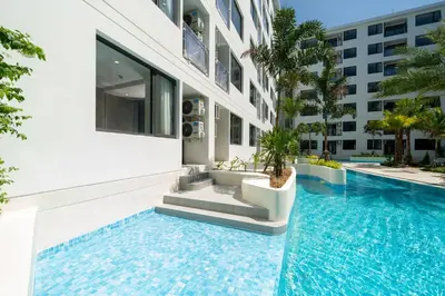 a swimming pool in front of a building at Capri Residence Bangtao in Ban Thalat Choeng Thale