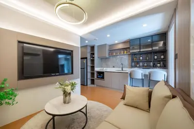a living room with a couch and a tv at Capri Residence Bangtao in Ban Thalat Choeng Thale