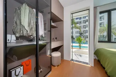a bedroom with a bed and a view of a pool at Capri Residence Bangtao in Ban Thalat Choeng Thale