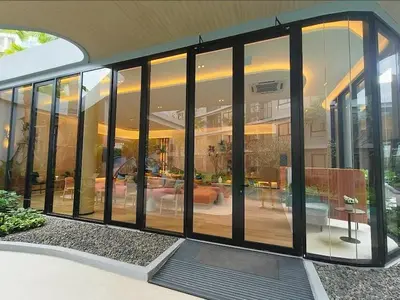 a house with large glass windows and a patio at D Condo Reef Kathu,Near Patong beach in Kathu
