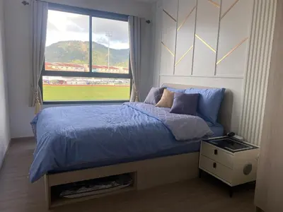a bedroom with a bed with a view of a baseball game at D Condo Reef Kathu,Near Patong beach in Kathu