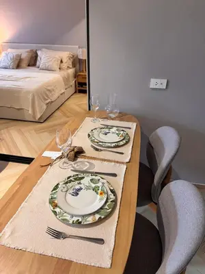 a table with two plates and wine glasses on it at The Title Legendary Bang-Tao Garden Harmony I-406 in Bang Tao Beach