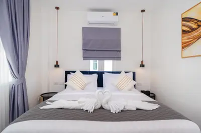 a bedroom with a bed with two white towels at Heart Patong pool villa with 5bedrooms in Patong Beach