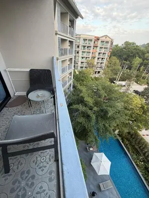 a balcony with a table and a chair on a building at 1 BDR 5 Swimming Pool Entire Apt Complex 5 Mins WALK To Naiyang Beach in Phuket