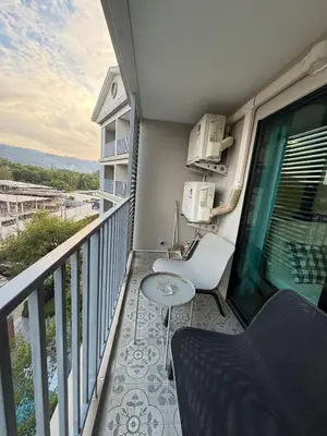 a balcony with a table and a chair at 1 BDR 5 Swimming Pool Entire Apt Complex 5 Mins WALK To Naiyang Beach in Phuket