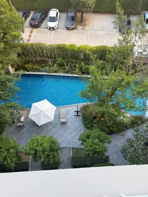 an overhead view of a swimming pool with an umbrella at 1 BDR 5 Swimming Pool Entire Apt Complex 5 Mins WALK To Naiyang Beach in Phuket