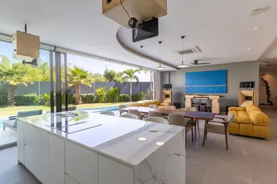 a kitchen and living room with a table and chairs at Lux Nine Pasak by MonthstayZ Thailand in Ban Pak Lak
