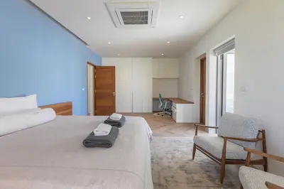 a bedroom with a bed and two chairs and a desk at Lux Nine Pasak by MonthstayZ Thailand in Ban Pak Lak