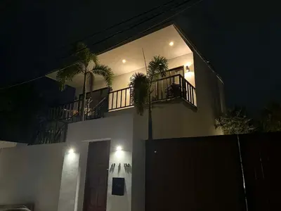 a building with a balcony with palm trees on it at Upstairs in Rawai Beach