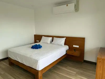 a bedroom with a bed with blue pillows on it at Upstairs in Rawai Beach