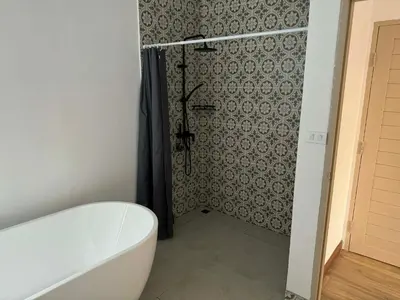 a bathroom with a bath tub and a shower at Upstairs in Rawai Beach
