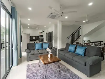 a living room with two couches and a table at Brand New Private pool villa Chalong Phuket Mountain view in Ban Klang