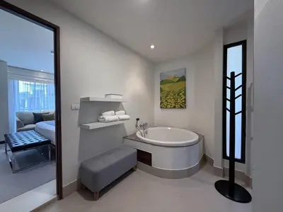 a white bathroom with a tub and a bedroom at Dewa 1302 Poolside Resort Spacious 2 Bedroom in Phuket Town