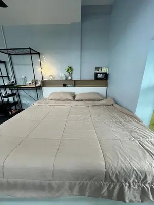 a large bed in a room with a blue wall at Spacious Garden Loft Home Studio Workation & Fit in Ban Na Nai