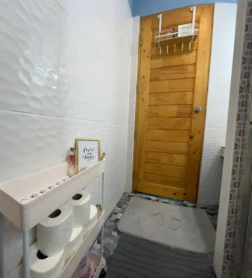 a bathroom with a sink and a wooden door at Spacious Garden Loft Home Studio Workation & Fit in Ban Na Nai