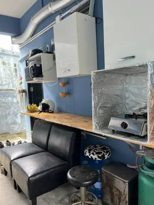 a living room with a black leather couch and a counter at Spacious Garden Loft Home Studio Workation & Fit in Ban Na Nai