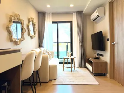 a living room with a couch and a television at Gloria's Laguna Nest in Ban Thalat Choeng Thale