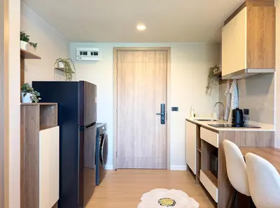 a kitchen with a black refrigerator and a table at Gloria's Laguna Nest in Ban Thalat Choeng Thale