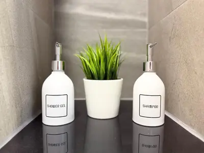 three bottles sitting on a counter next to a plant at Gloria's Laguna Nest in Ban Thalat Choeng Thale