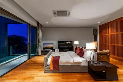 a bedroom with a bed and a large window at Absolute Beachfront Villa 3-Bedroom in Rawai in Ban Saiyuan (1)