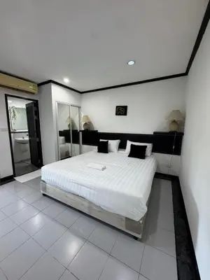 a bedroom with a large bed with white sheets and pillows at Pathaya in Ban Kata