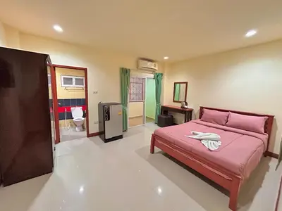 a bedroom with a pink bed and a bathroom at Khan House Patong in Patong Beach