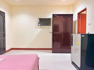 a room with a refrigerator and a tv on the wall at Khan House Patong in Patong Beach