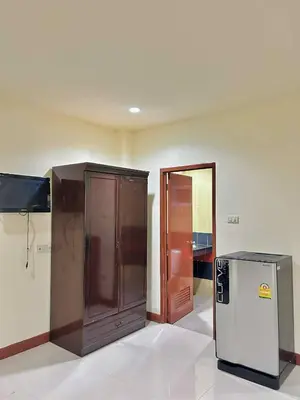 an empty room with a refrigerator and a door at Khan House Patong in Patong Beach