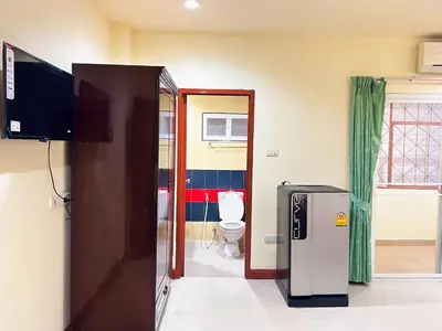 a bathroom with a toilet and a television in a room at Khan House Patong in Patong Beach