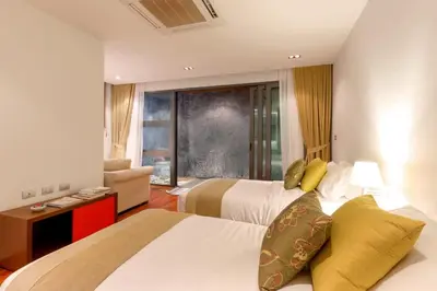 a hotel room with two beds and a couch at 4-Bed Villa-Sweeping Sunrise View over Chalong Bay in Ban Saiyuan (1)