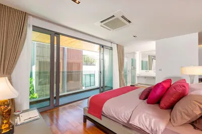 a bedroom with a bed with red pillows on it at 4-Bed Villa-Sweeping Sunrise View over Chalong Bay in Ban Saiyuan (1)