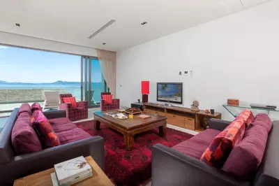 a living room with a couch and a table at 4-Bed Villa-Sweeping Sunrise View over Chalong Bay in Ban Saiyuan (1)