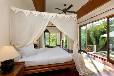 a bedroom with a canopy bed and a large window at Villa Barron - Spacious Luxury Family Holiday Home in Chalong
