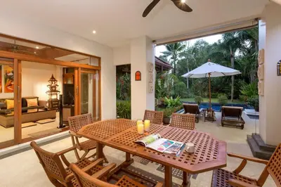 a dining room with a table with chairs and an umbrella at Villa Barron - Spacious Luxury Family Holiday Home in Chalong