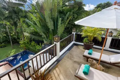 a balcony with an umbrella and a pool at Villa Barron - Spacious Luxury Family Holiday Home in Chalong