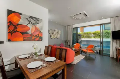 a living room with a table and orange chairs at 2-Bed Pool Villa Chalong-Bright Modern & Relaxing in Ban Suan