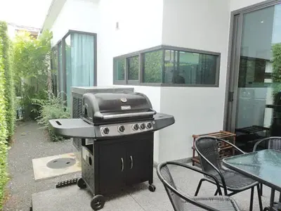 a grill sitting on a patio with a table and chairs at 2-Bed Pool Villa Chalong-Bright Modern & Relaxing in Ban Suan
