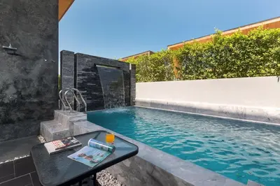 a swimming pool with a table in front of a house at 2-Bed Pool Villa Chalong-Bright Modern & Relaxing in Ban Suan