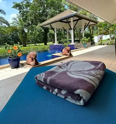 two stuffed animals sitting next to a swimming pool at Peaceful 2-Bedroom Villa on Loch Palm Golf Course in Ban Kathu