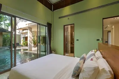 a bedroom with a large bed and a pool at Diamond Tree Escape Pool Villa in Bangtao in Ban Pak Lak