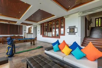 a living room with a couch and a pool table at Villa Elan Luxury Surin Villa Panoramic Sea Views in Surin Beach
