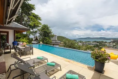 a swimming pool with chairs and a table at Villa Elan Luxury Surin Villa Panoramic Sea Views in Surin Beach