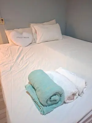 a white bed with towels and pillows on it at Budget Place Homestay-Solo Traveler in Ban Dan