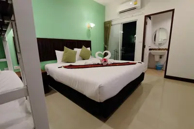 a bedroom with a large white bed with a bow on it at BS Airport at Phuket in Nai Yang Beach