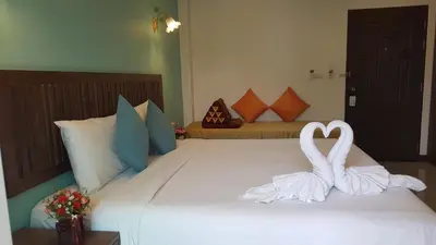 a bed with two white towels on it at BS Airport at Phuket in Nai Yang Beach