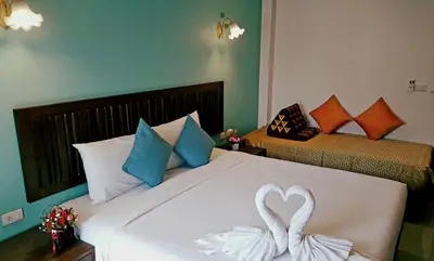 two swans making a heart shape on a bed at BS Airport at Phuket in Nai Yang Beach