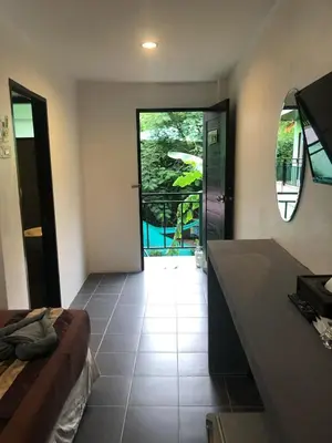 a room with a bed and a door with a window at Phi Phi Green House & Sunsky Hostel in Phi Phi Don