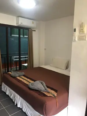 a bedroom with a bed with two towels on it at Phi Phi Green House & Sunsky Hostel in Phi Phi Don