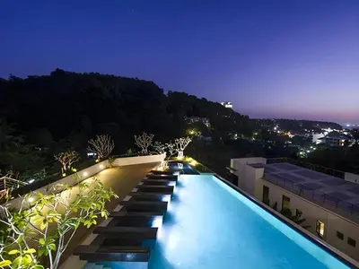 a swimming pool on top of a building at night at Veloche Karon by Investing In Phuket in Ban Karon